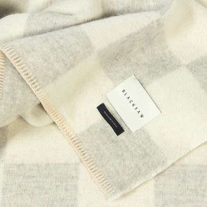 The Blacksaw Checkerboard Crosby Blanket in light Heather Grey and White Close Up product shot showing beautiful brand label and Blanket Stitching detail