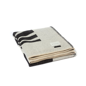The Blacksaw Dopamine Psychedelic Art Blanket in Black/Ivory, folded product shot with beautiful Blanket Stitching and branded label