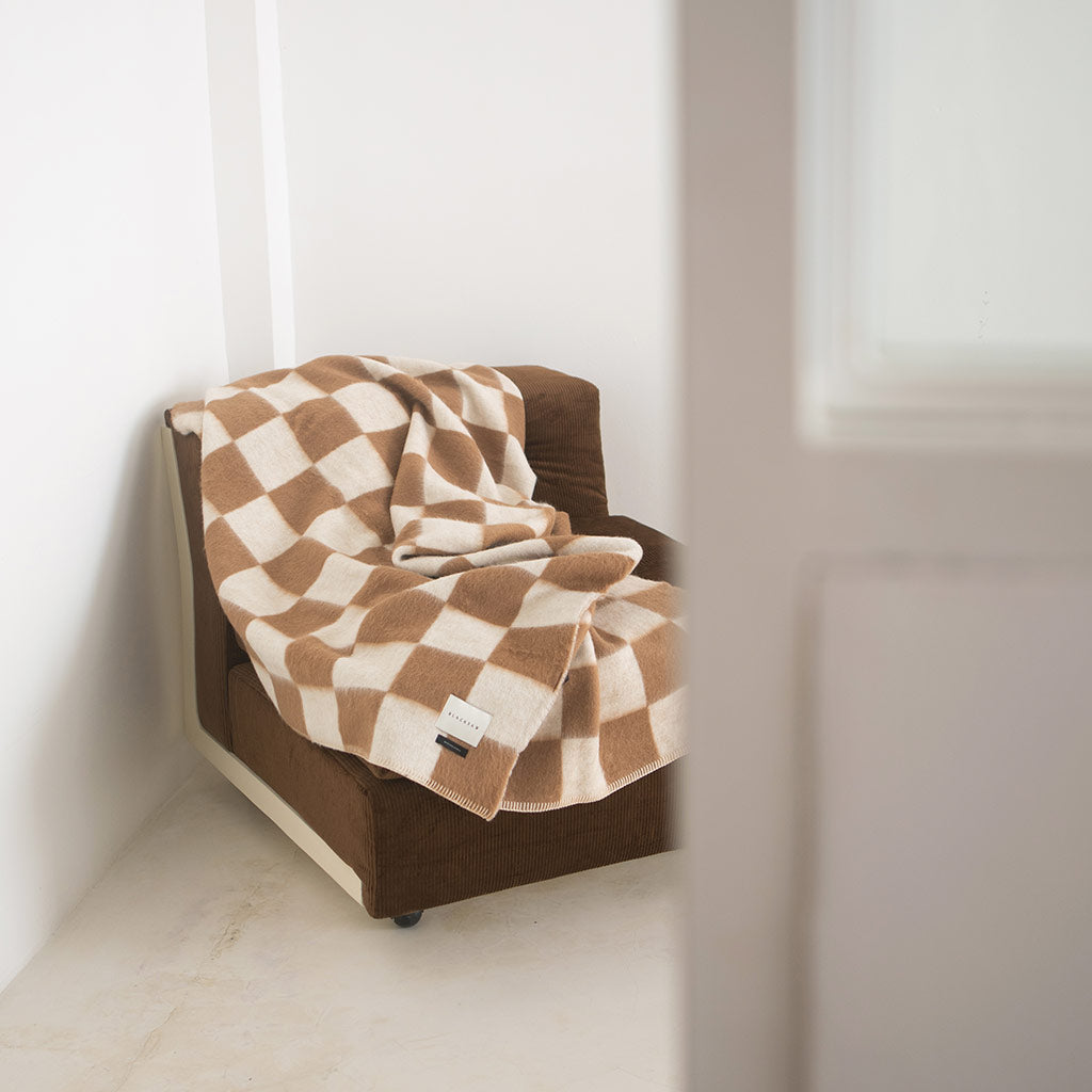 The Blacksaw Checkerboard Crosby Blanket in Tabacco Brown, Flat laying product shot