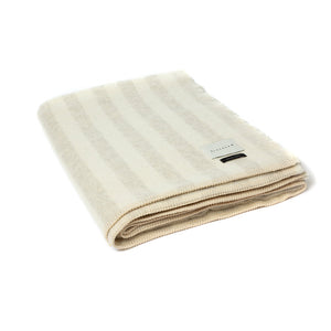 The Blacksaw Stills Vertical Stripe Blanket in Shoji Beige/Ivory, folded product shot with beautiful Blanket Stitching and branded label