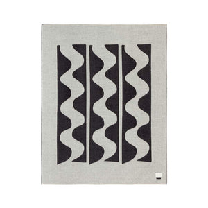 The Blacksaw 100% Alpaca, Reversible TimeWarp Throw Blanket laying flat in Black and Ivory 