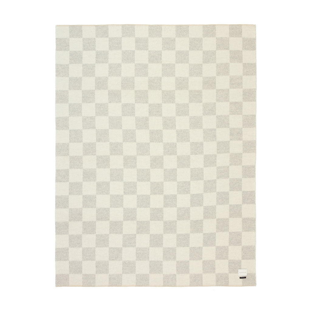 The Blacksaw Checkerboard Crosby Blanket in Light heather Grey and White   Flat laying product shot