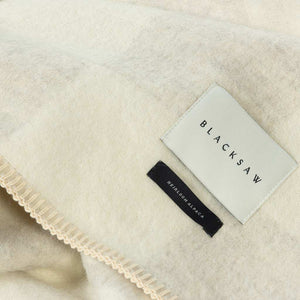 The Blacksaw Checkerboard Crosby Blanket in Shoji Beige Close Up product shot showing beautiful Blacksaw brand label, Heirloom Alpaca label and Blanket Stitching detail