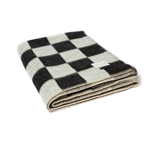The Blacksaw Checkerboard Crosby Blanket folded product shot in Black and White with Blanket Stitching