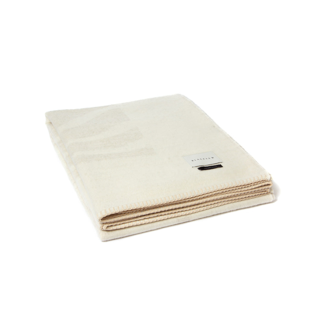 The Blacksaw Dopamine Psychedelic Art Blanket in Ivory/Shoji Beige colour, folded product shot with beautiful Blanket Stitching and branded label