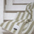 The Blacksaw Stills Vertical Stripe Blanket in Boa Green Flat laying product shot