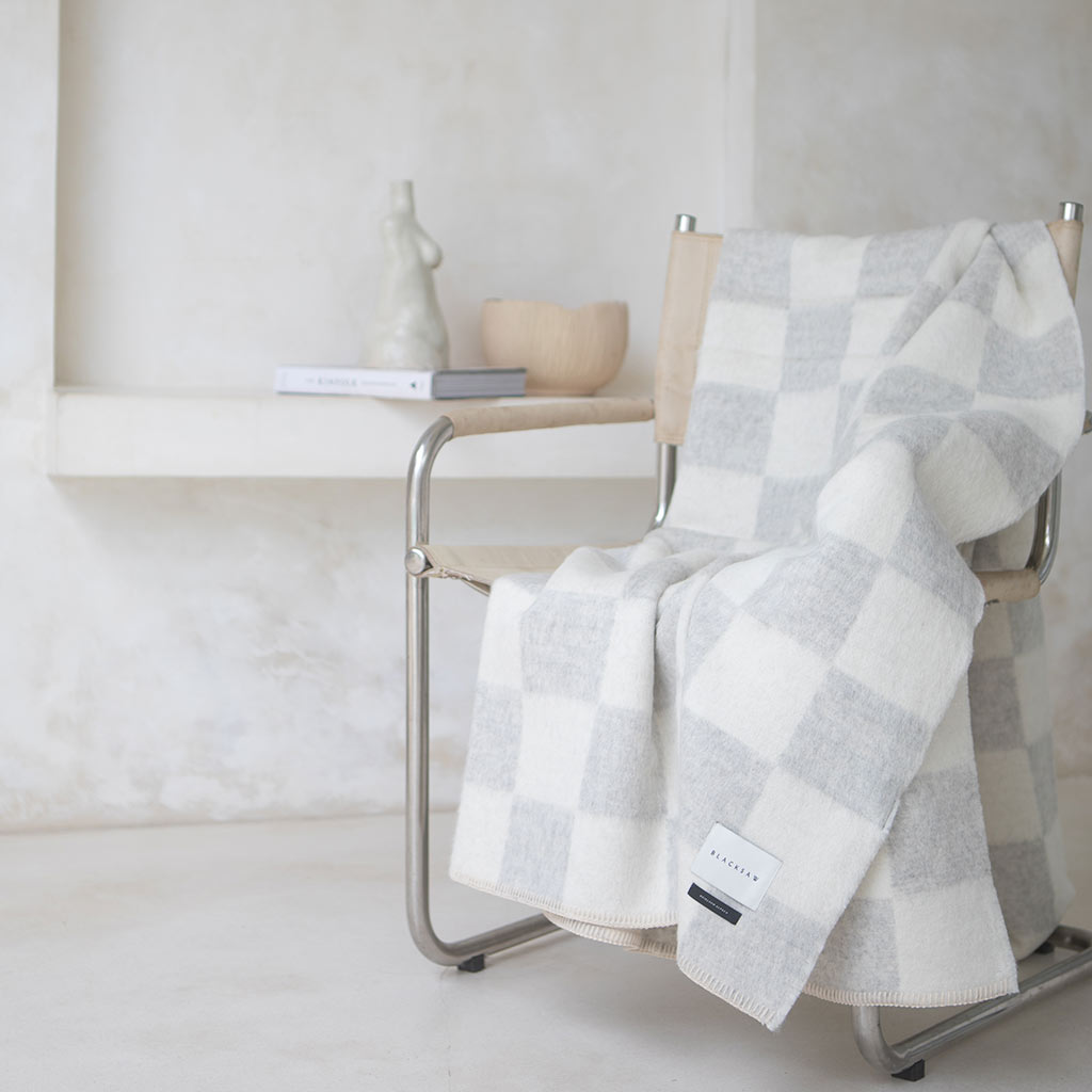 The Blacksaw Checkerboard Crosby Blanket in Light heather Grey and White   Flat laying product shot