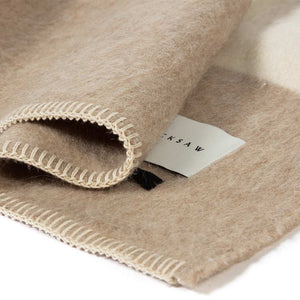 The Blacksaw  100% Recycled Siempre Blanket Blanket in  Beige with Ivory Stripe Close Up product shot showing beautiful brand label and Blanket Stitching detail