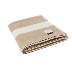 The Blacksaw 100% Recycled Siempre Blanket in Beige with Ivory Stripe, folded product shot with beautiful Blanket Stitching and branded label 