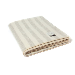 The Blacksaw Stills Vertical Stripe Blanket in Light heather Grey/Ivory, folded product shot with beautiful Blanket Stitching and branded label 