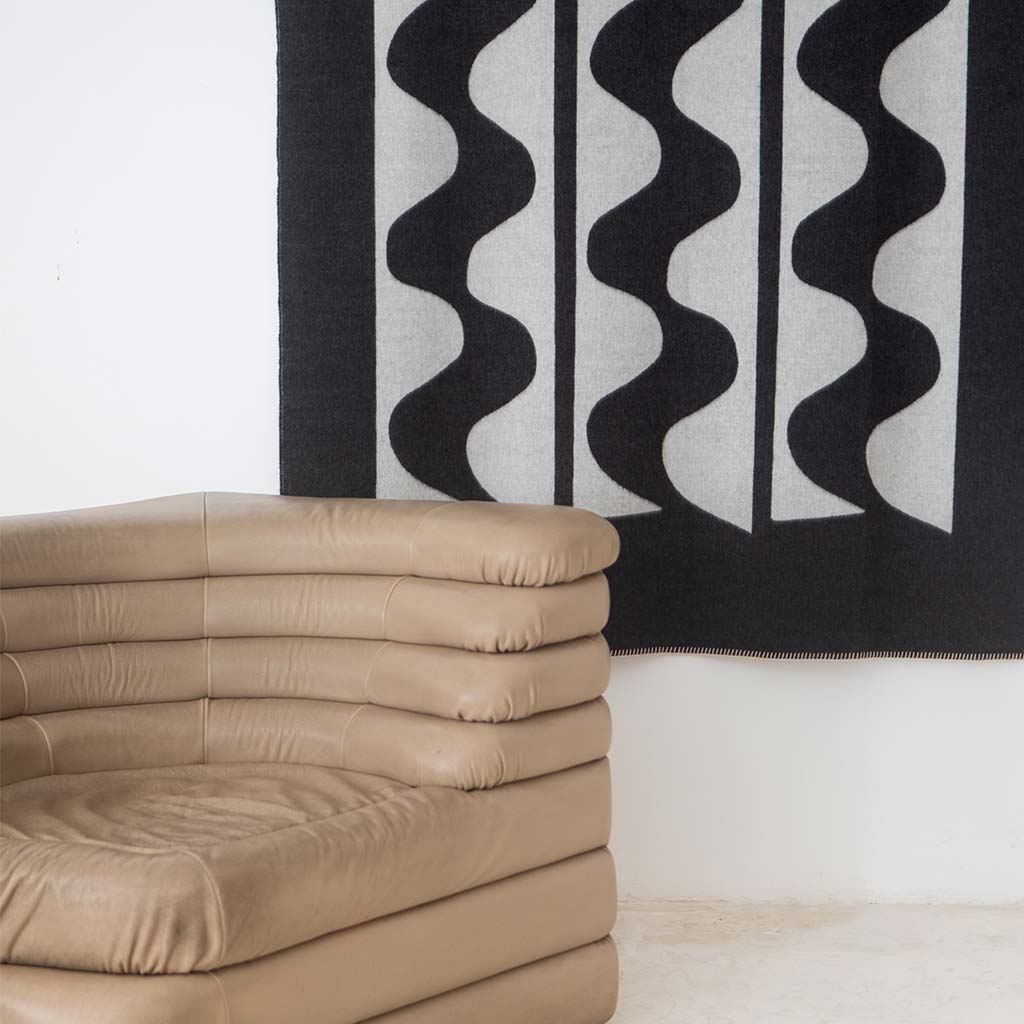 The Blacksaw 100% Alpaca, Reversible TimeWarp Throw Blanket laying flat in Black and Ivory 