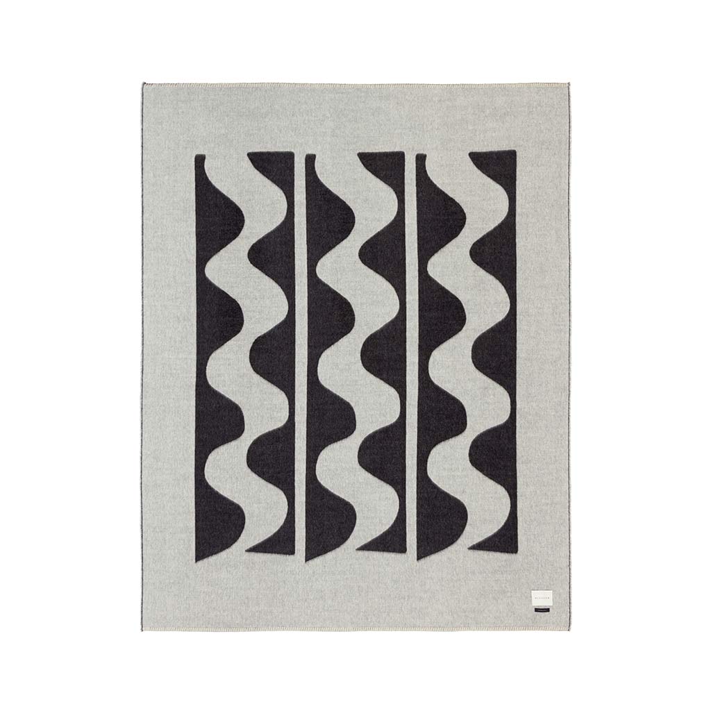 The Blacksaw 100% Alpaca, Reversible TimeWarp Throw Blanket laying flat in Black and Ivory 