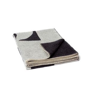 The Blacksaw 100% Alpaca, Reversible TimeWarp Throw Blanket in Black and Ivory folded product shot with beautiful Blanket Stitching